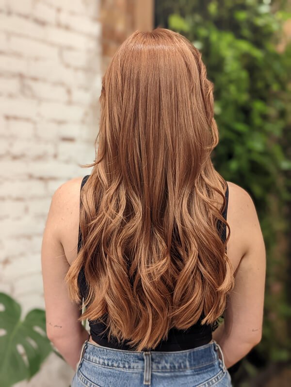 Long copper hair finished in glossy waves at Bohem Dreme